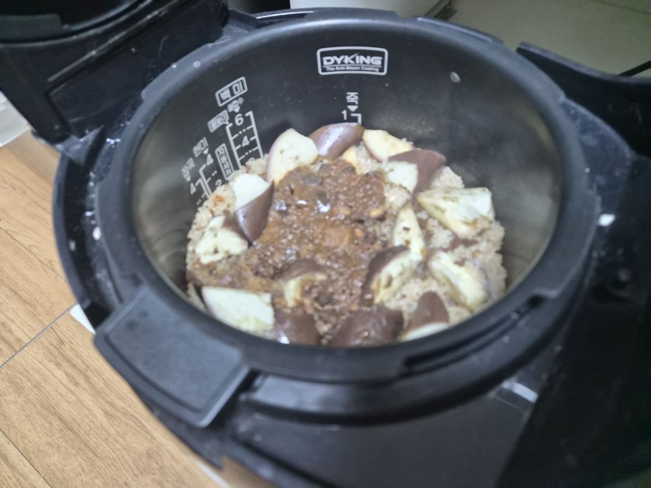 炊飯器の中でご飯の上にのったナスと牛肉ソース